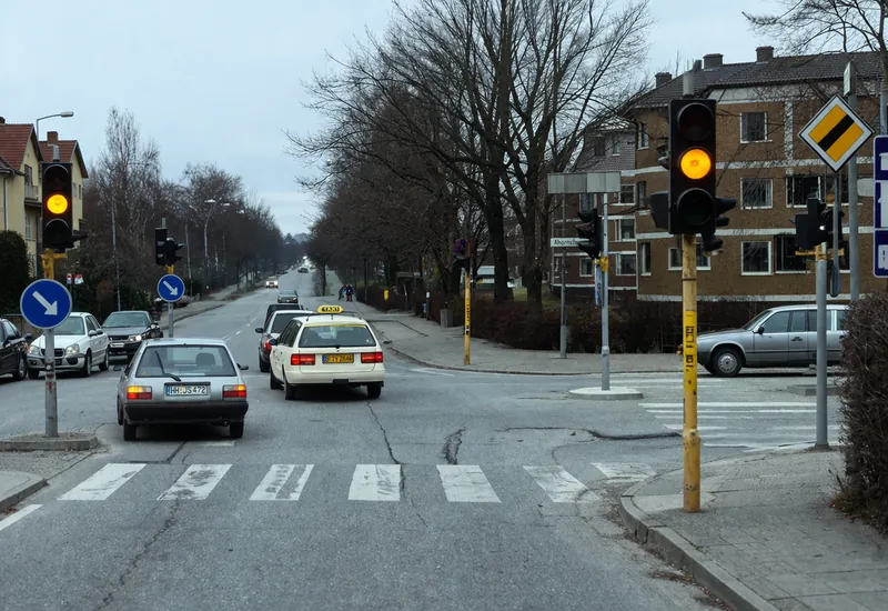 You are driving at a speed of 50 km/h, and at that moment the traffic light suddenly turns yellow. What do you do?